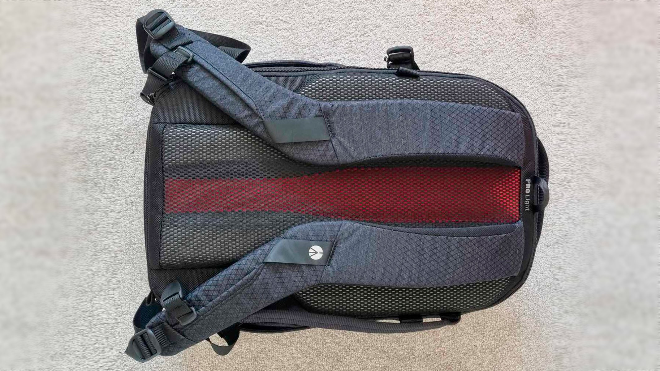 Camera backpack placed rear side up on a carpet