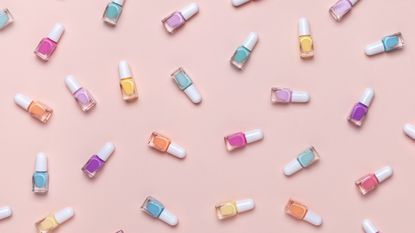 An assortment of pastel-colored nail polish paints on pink background