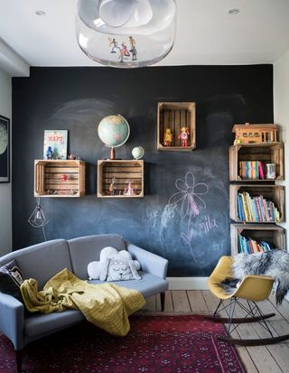playroom with chalkboard wall and wall-mounted wooden crates used as storage