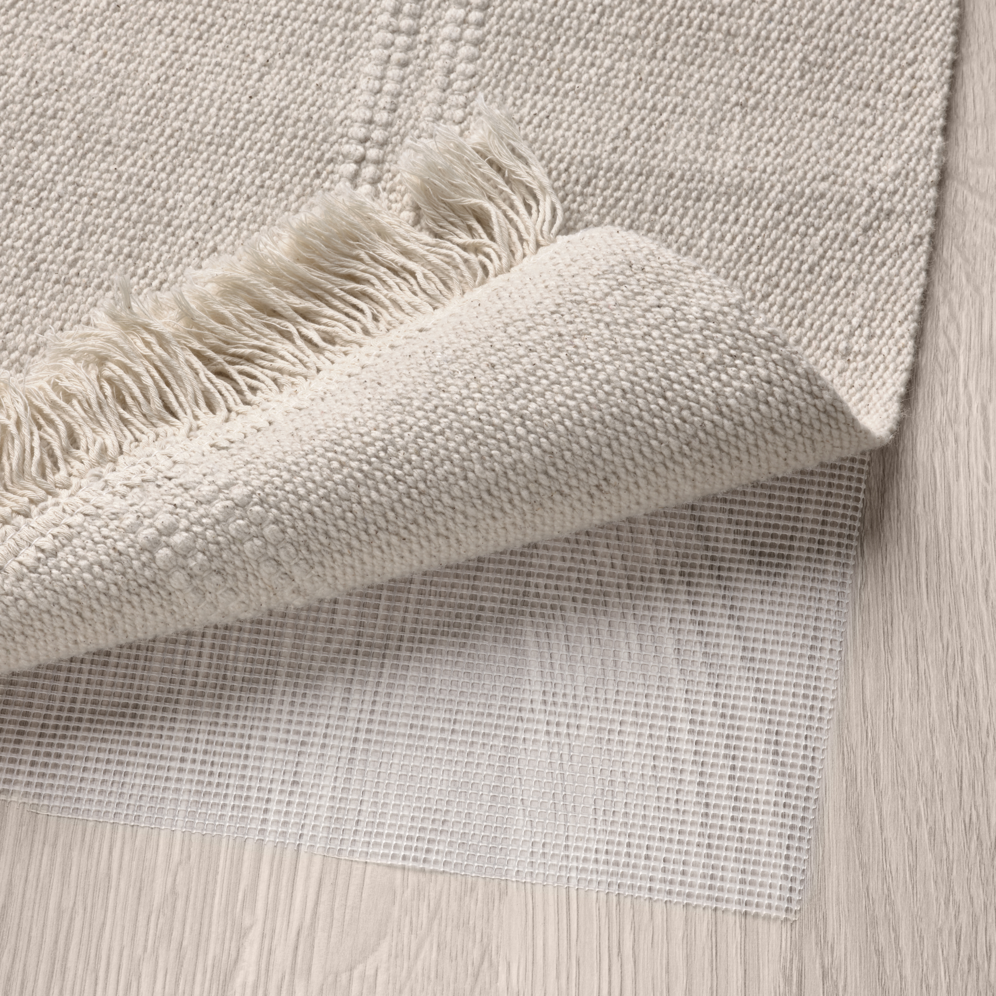 A beige, flatwoven rug