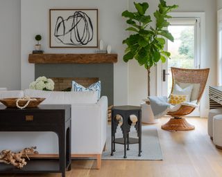 A modern farmhouse-style living room with white sofa, rattan armchair and banana indoor tree