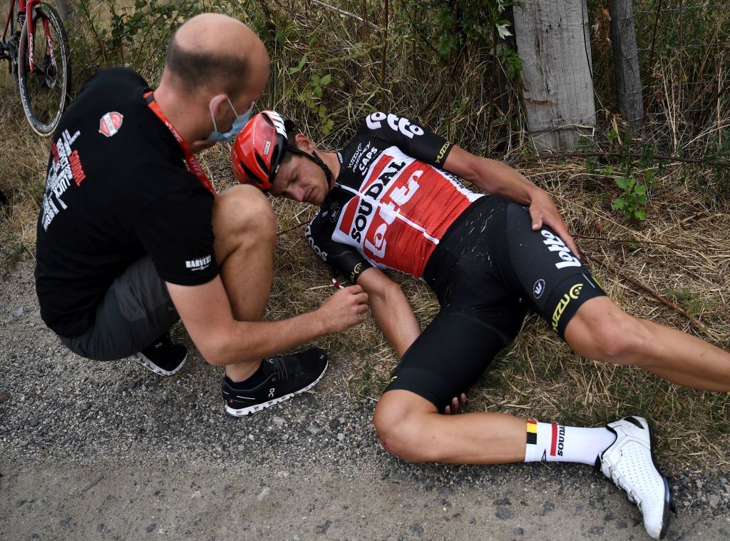 Team Lotto rider Belgiums Brent Van Moer R receives medical assistance after falling during the first stage of the 72nd edition of the Criterium du Dauphine cycling race 2185 km between ClermontFerrand and SaintChristoenJarez on August 12 2020 Photo by AnneChristine POUJOULAT AFP Photo by ANNECHRISTINE POUJOULATAFP via Getty Images