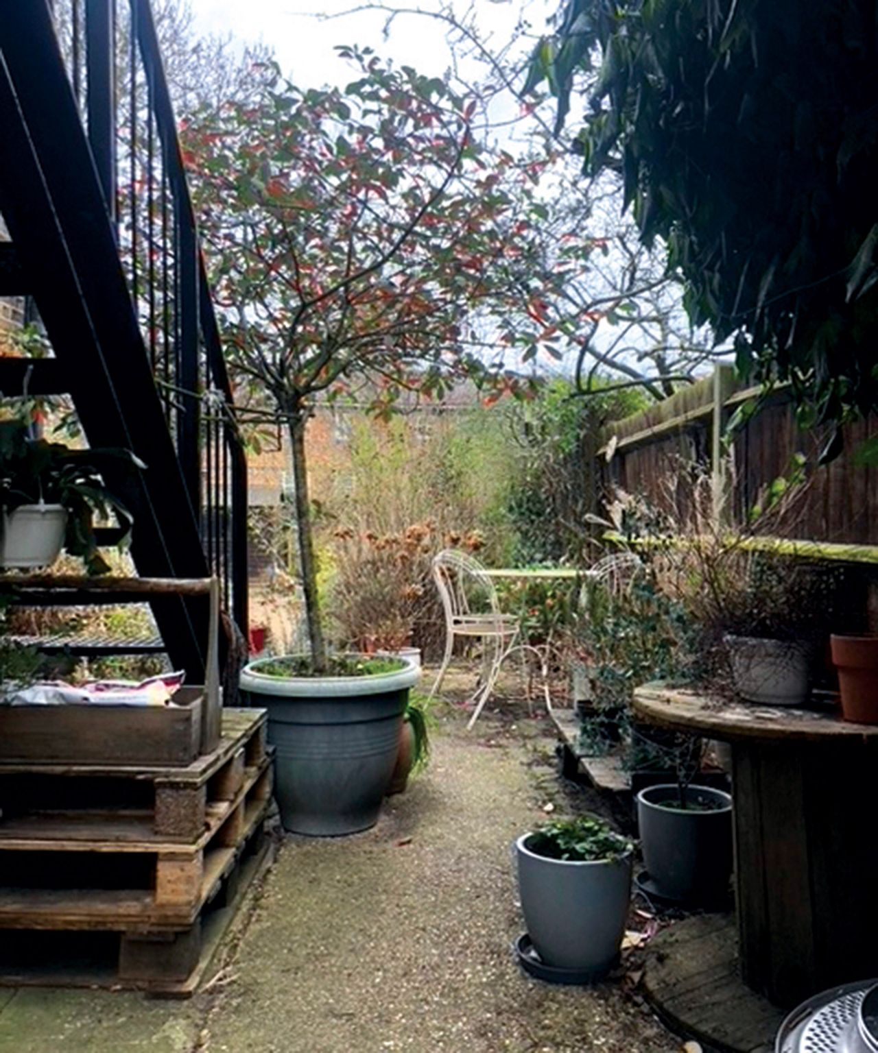 Before shot of a disused courtyard with industrial staircase and disused pots