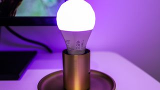 Nanoleaf Essentials smarta lampa i en enkel armatur på ett bord.