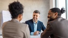 A financial adviser meets with clients in his office.