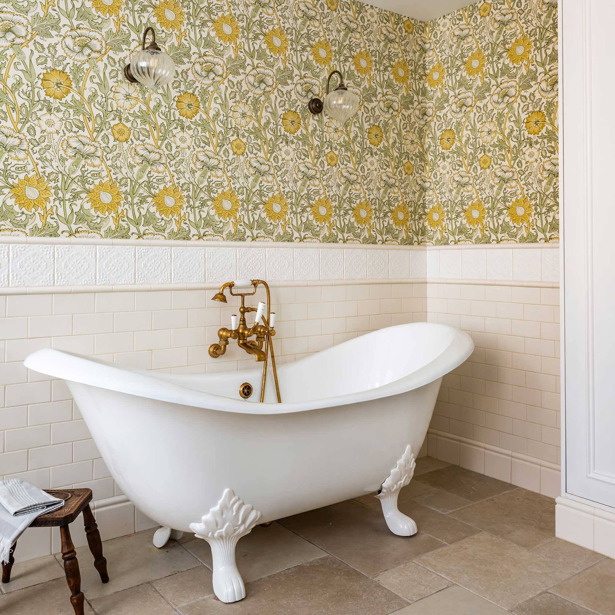 freestanding tub in a traditional style bathroom with arts and crafts design wallpaper