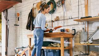 Image of woman in garage cleaning hedge trimmer