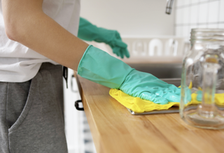 Woman using baking soda to clean her kitchen