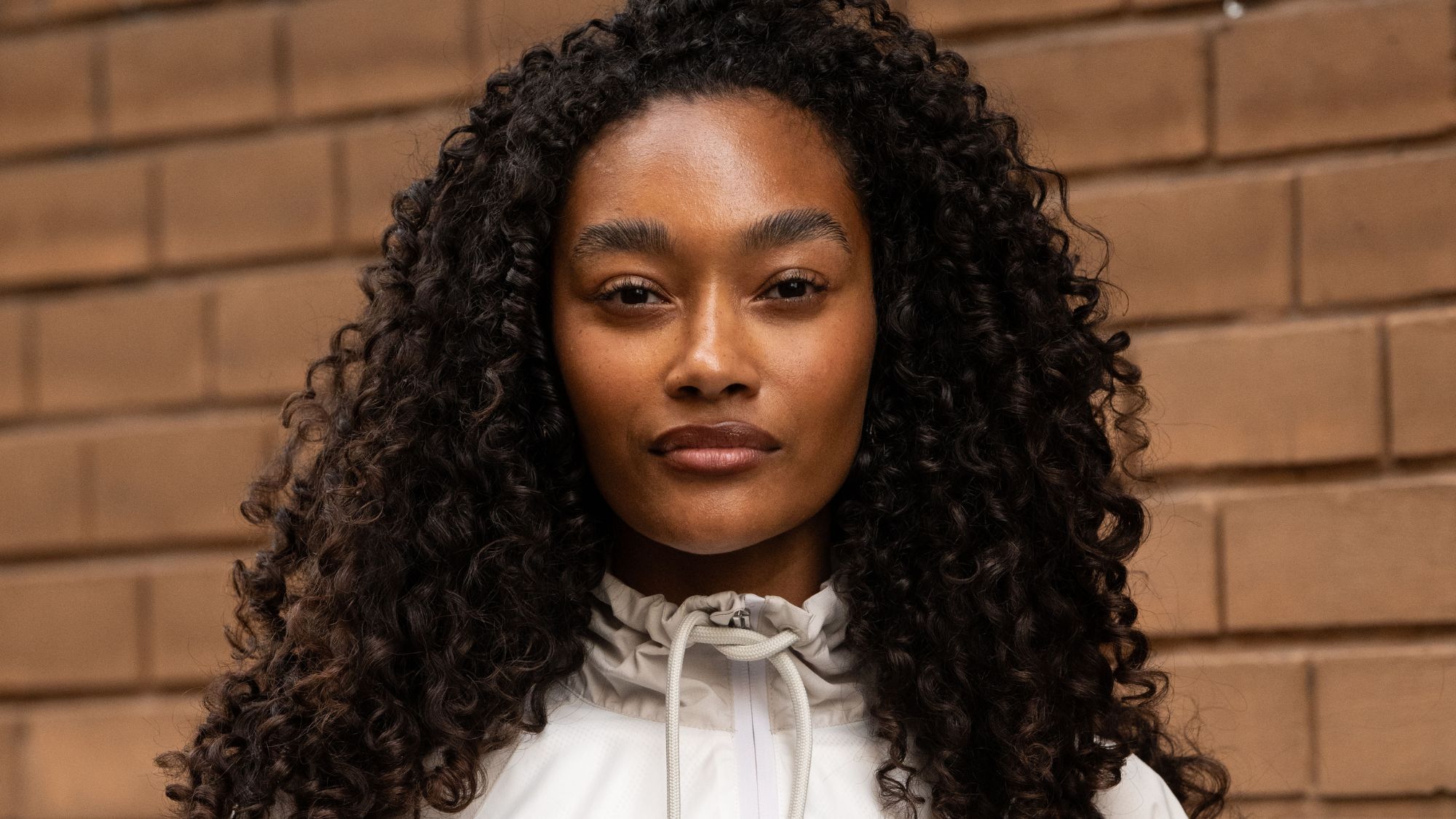 headshot of woman with long dark brown curly hair