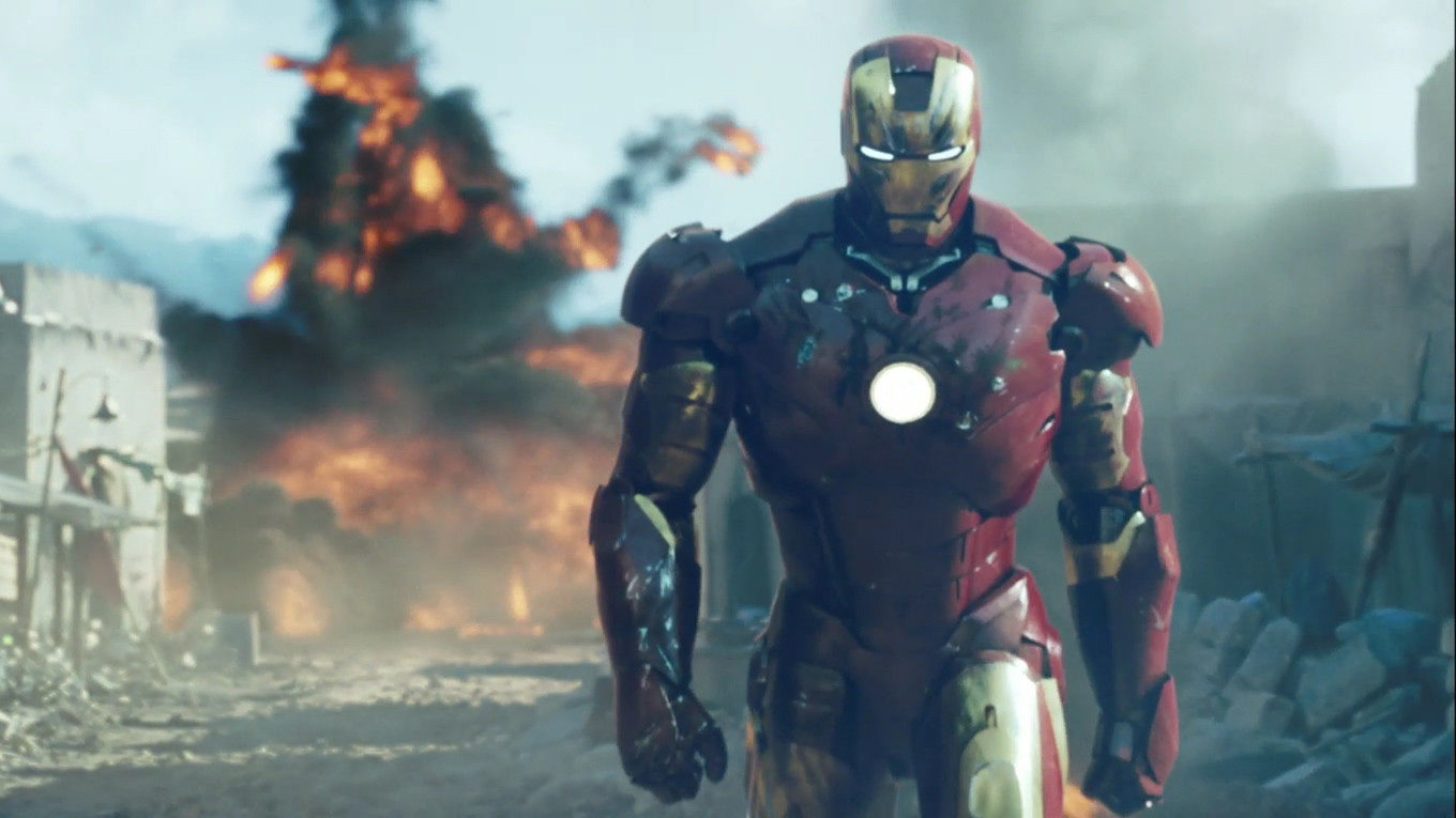 Tony Stark suited up and walking away from an explosion in Iron Man