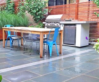 compact outdoor kitchen on a patio with an outdoor dining area