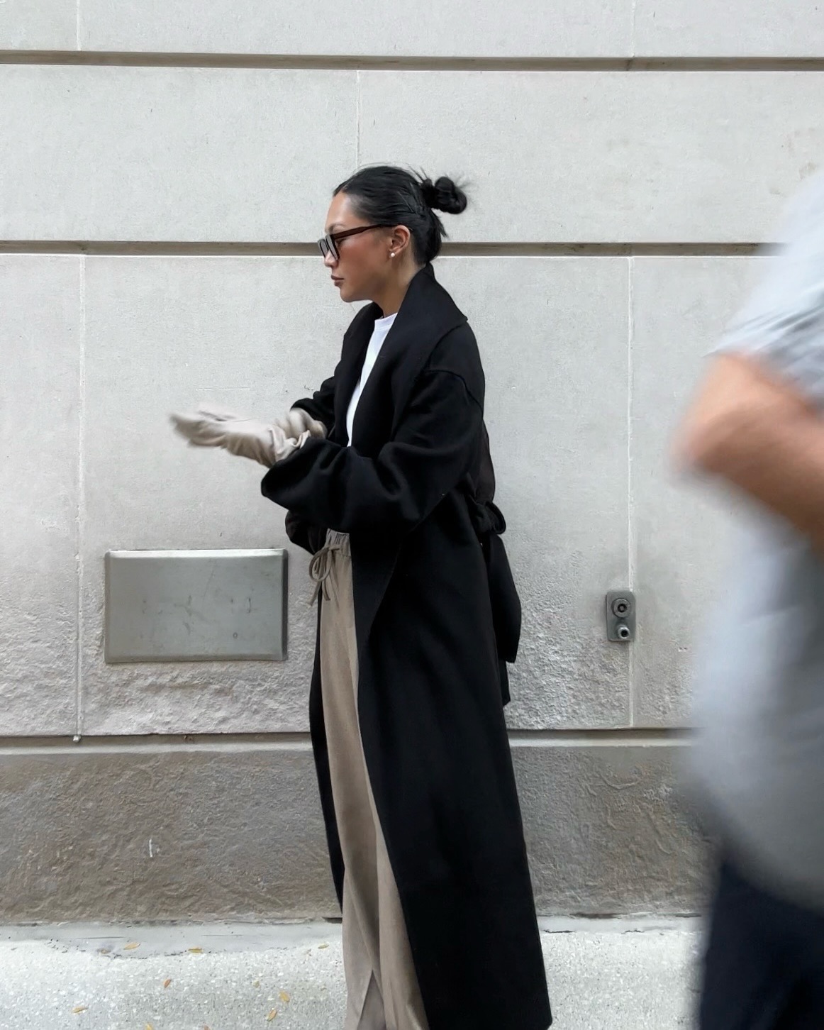 Dawn in black coat and beige trousers