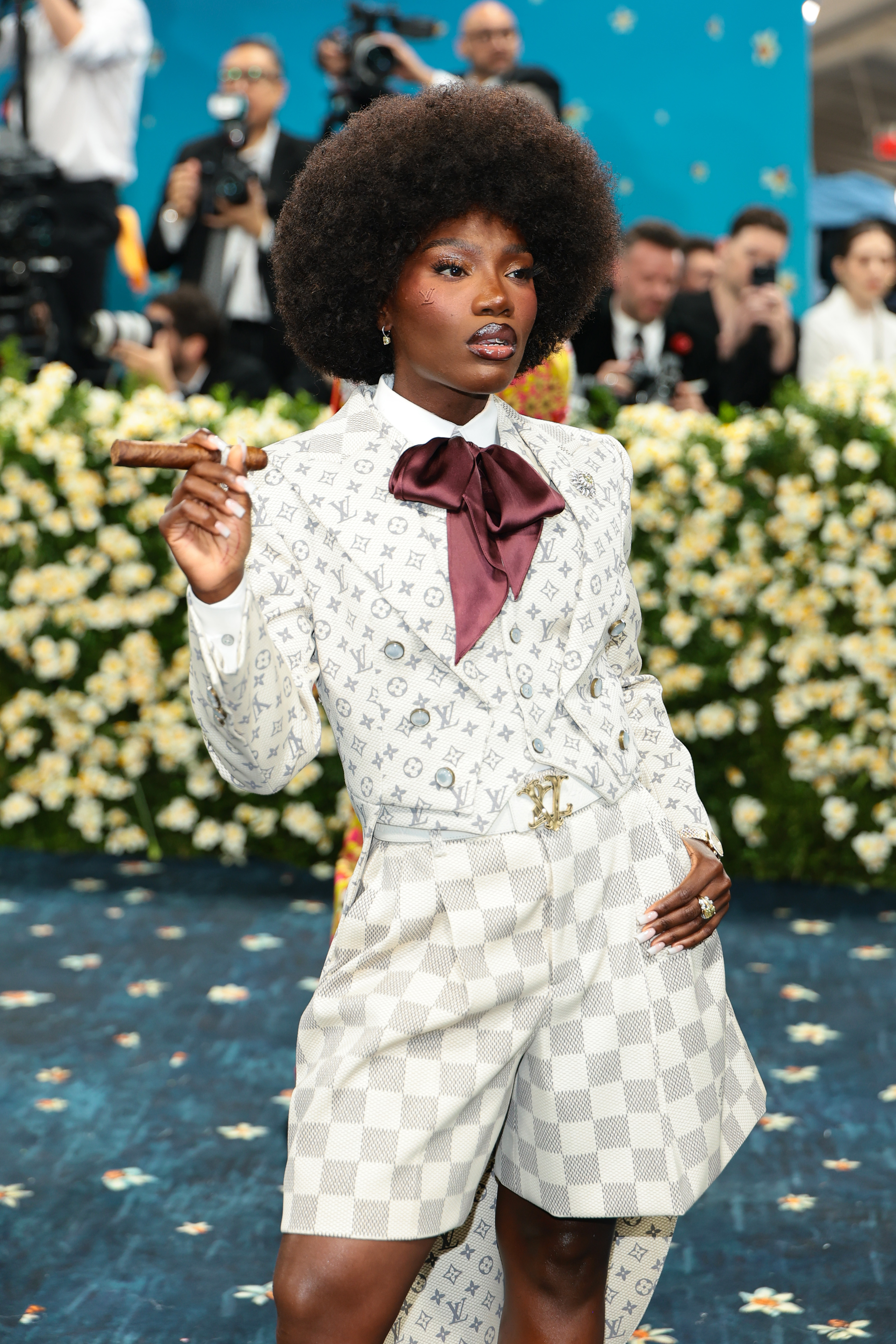 a women in a white and gray suit with an afro
