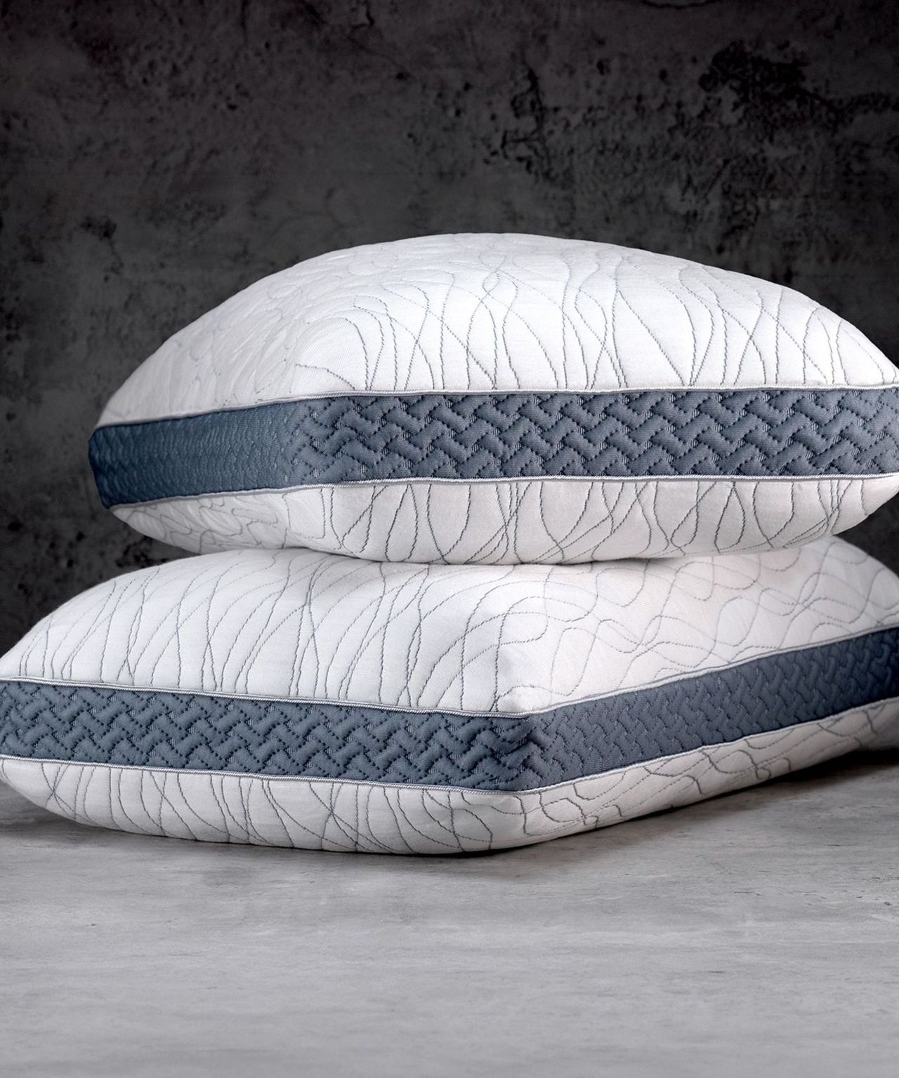 Two stacked Luxome LAYR pillows against a black background