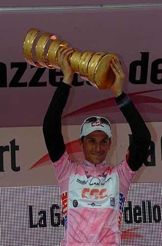 Ivan Basso holds aloft the Giro champion's trophy after dominating the race