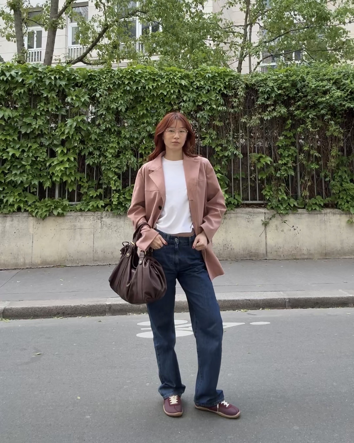 @kristinamichelleang wearing a pink blazer, dark-wash jeans, and sneakers in Paris.