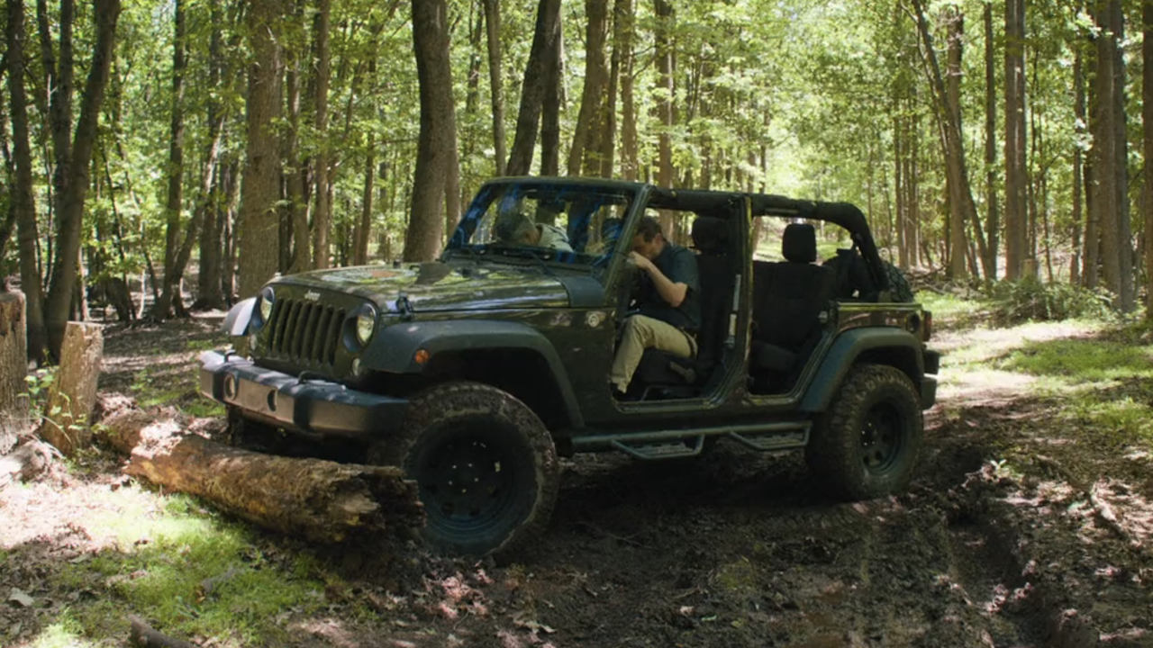 Ron slamming jeep into log during Jeep Tours in The Chair Company Season 1