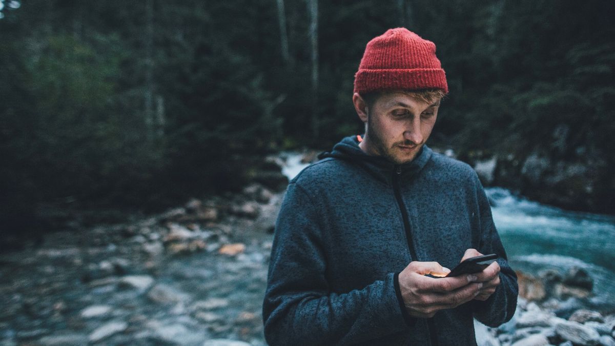 Hiker using cellphone in evening