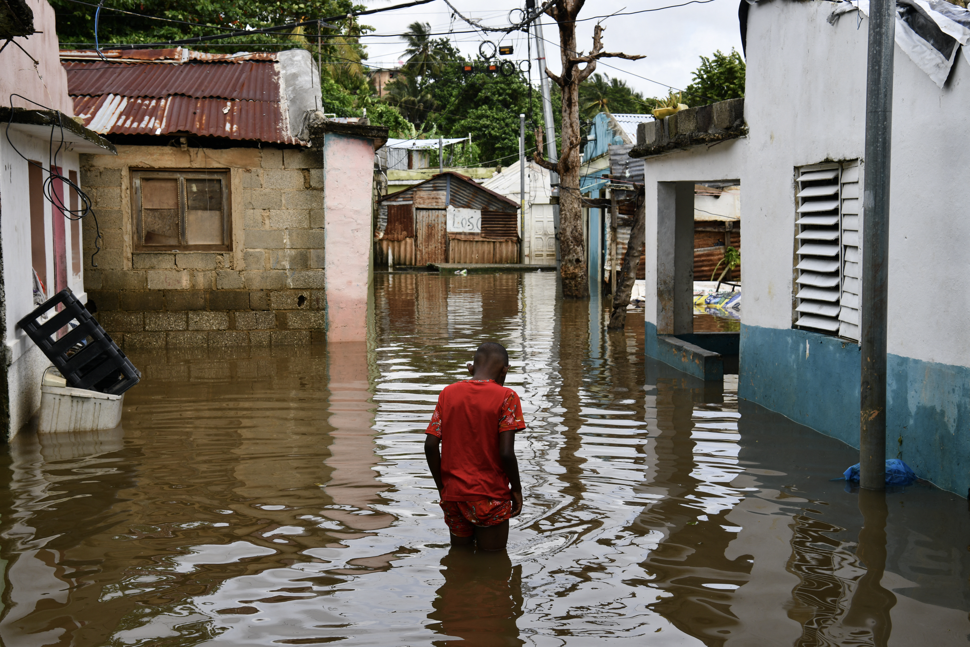 A man walks along a flooded street after the passing of the tropical storm Melissa before becoming a hurricane at Las Cucarachas neighborhood in Santo Domingo, Dominican Republic on October 28, 2025.