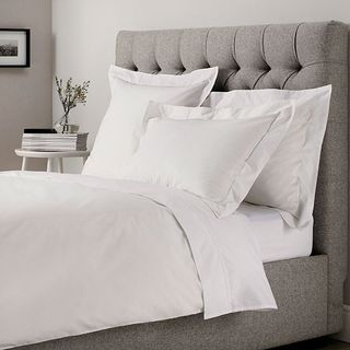 Bedroom with white and grey bedding and allergy pillows