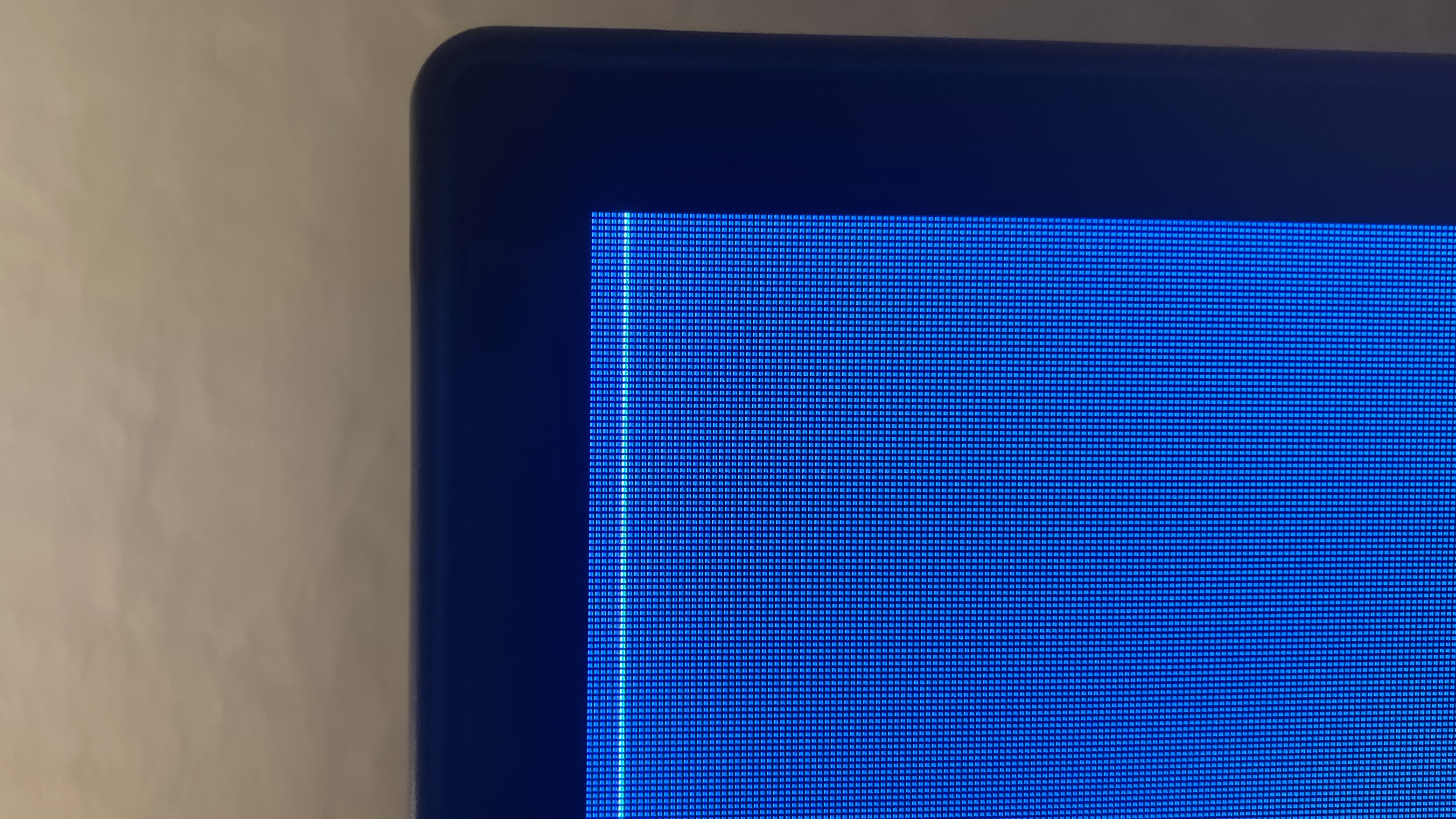A close-up of the top-left corner of an LG C1 OLED display. The panel is defective, as a vertical, white row of pixels extends from the top of the display all the way down to where the photo ends.