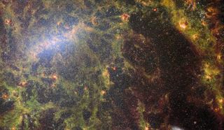 Green gas and stars shimmer in this JWST image of a spiral galaxy