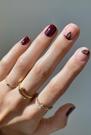 A manicure featuring hand-painted monarch butterflies by Betina Goldstein.