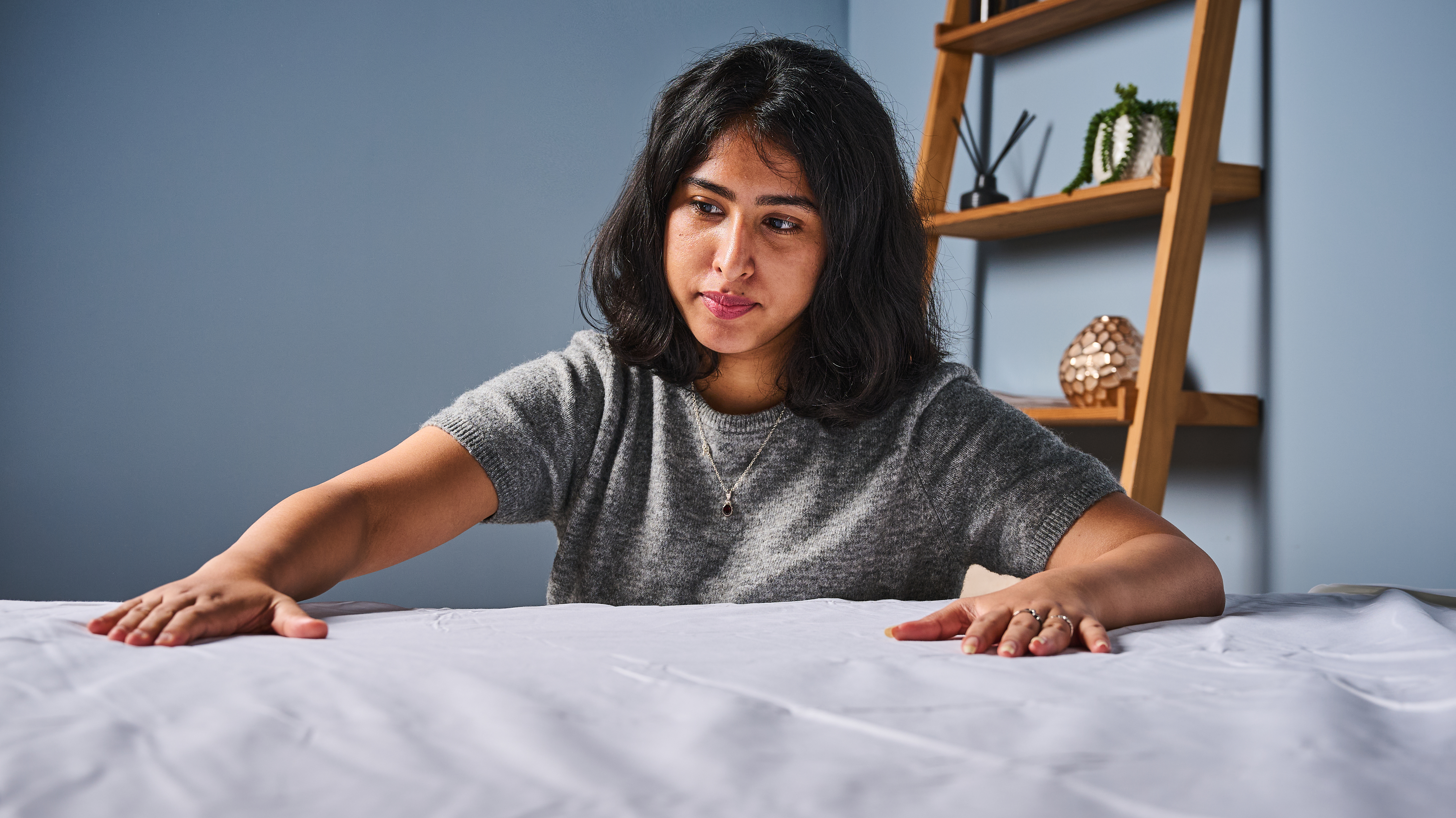 TG bedding writer placing hands on the Coop Cotton Percale sheet set