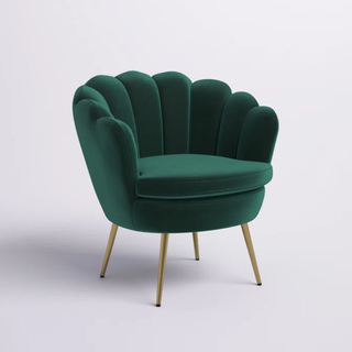 A dark green barrel chair with a scalloped edge on a white background