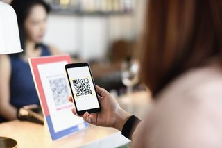 woman scanning QR with new NHS track and trace app