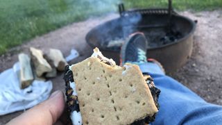 Person eating s'mores at a campfire
