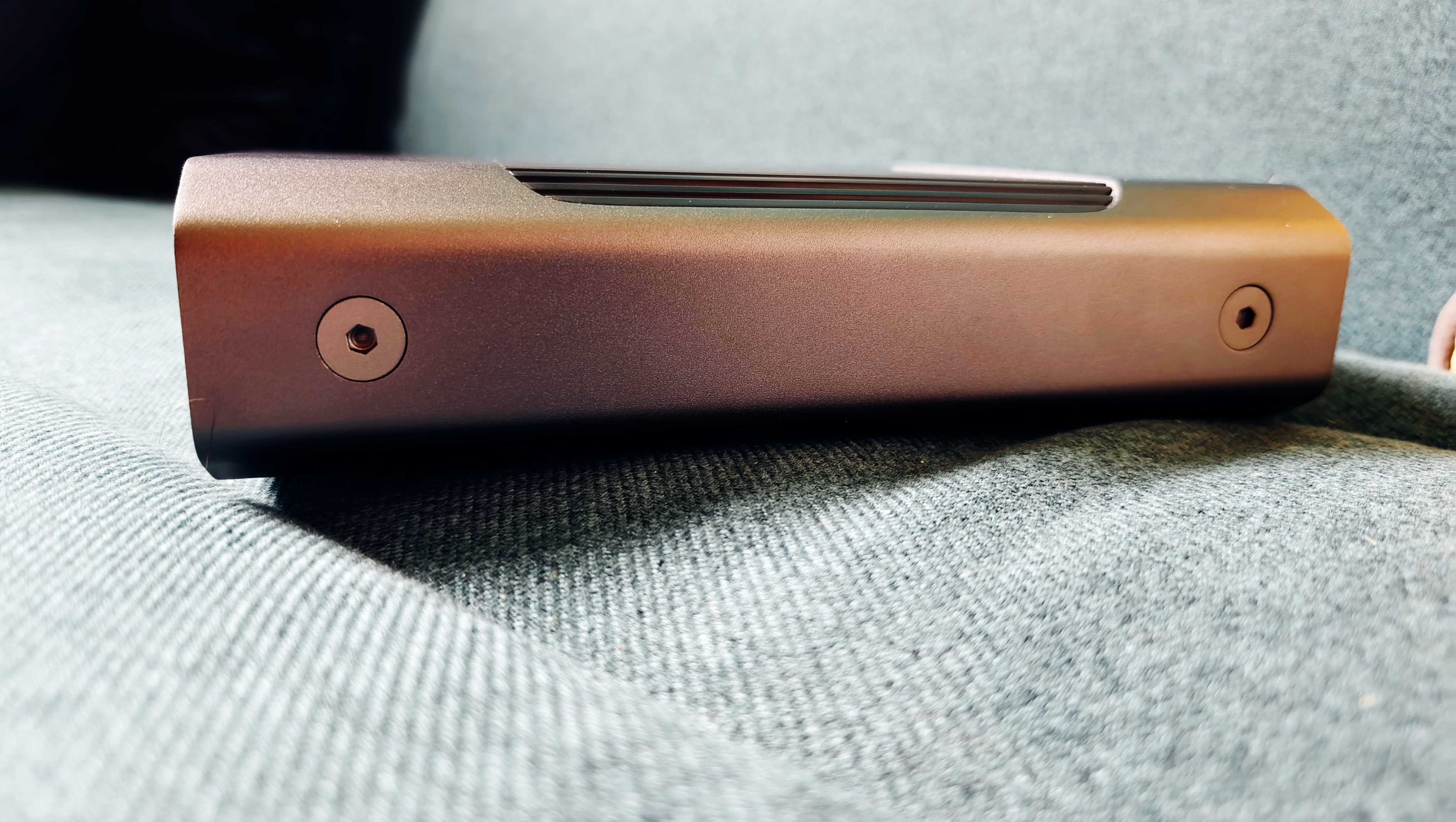A grey and black SanDisk G-Drive sitting on a green sofa