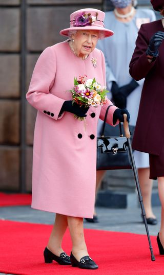 The Queen steps out with her walking stick as she attends the opening ceremony of the sixth session of the Senedd at The Senedd on October 14, 2021 in Cardiff, Wales
