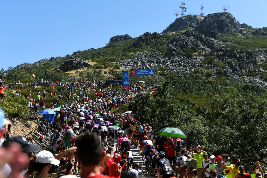 PICO VILLUERCAS SPAIN AUGUST 28 A general view of the peloton beginning to climb the Alto Collado de Ballesteros 1415m while fans cheer during the 76th Tour of Spain 2021 Stage 14 a 1657km stage from Don Benito to Pico Villuercas 1580m lavuelta LaVuelta21 on August 28 2021 in Pico Villuercas Spain Photo by Tim de WaeleGetty Images