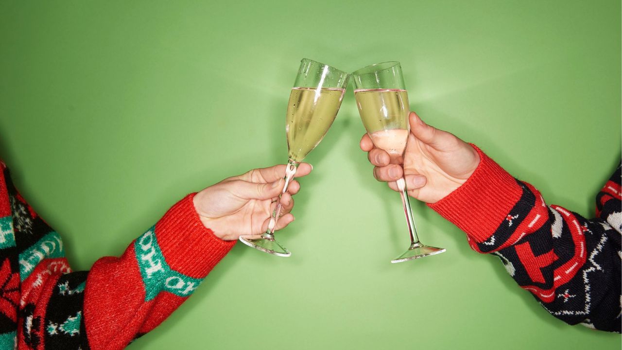 Two women's hands cheers with glass of alcohol