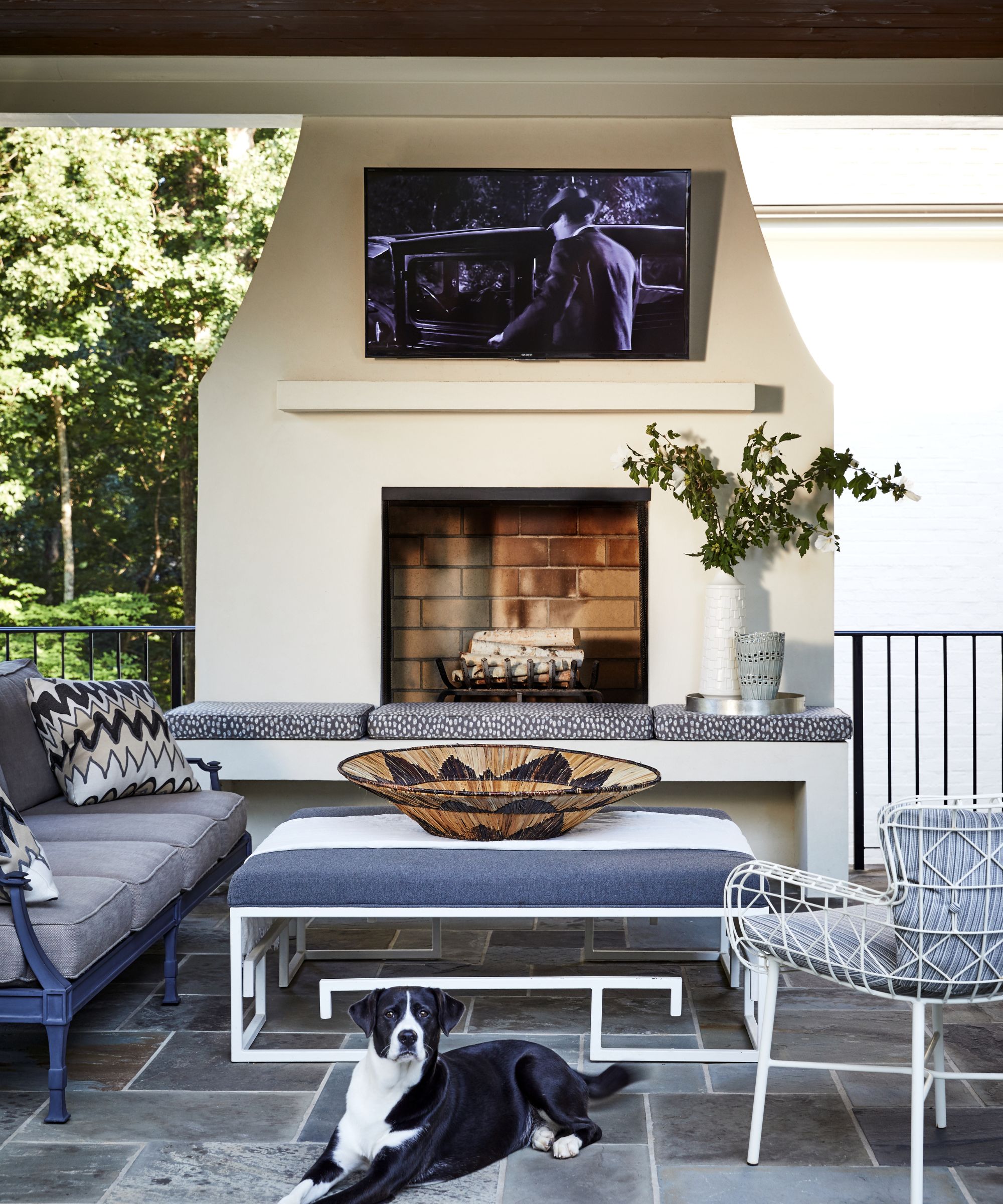 Outdoor fireplace with metal seating and bench and tv