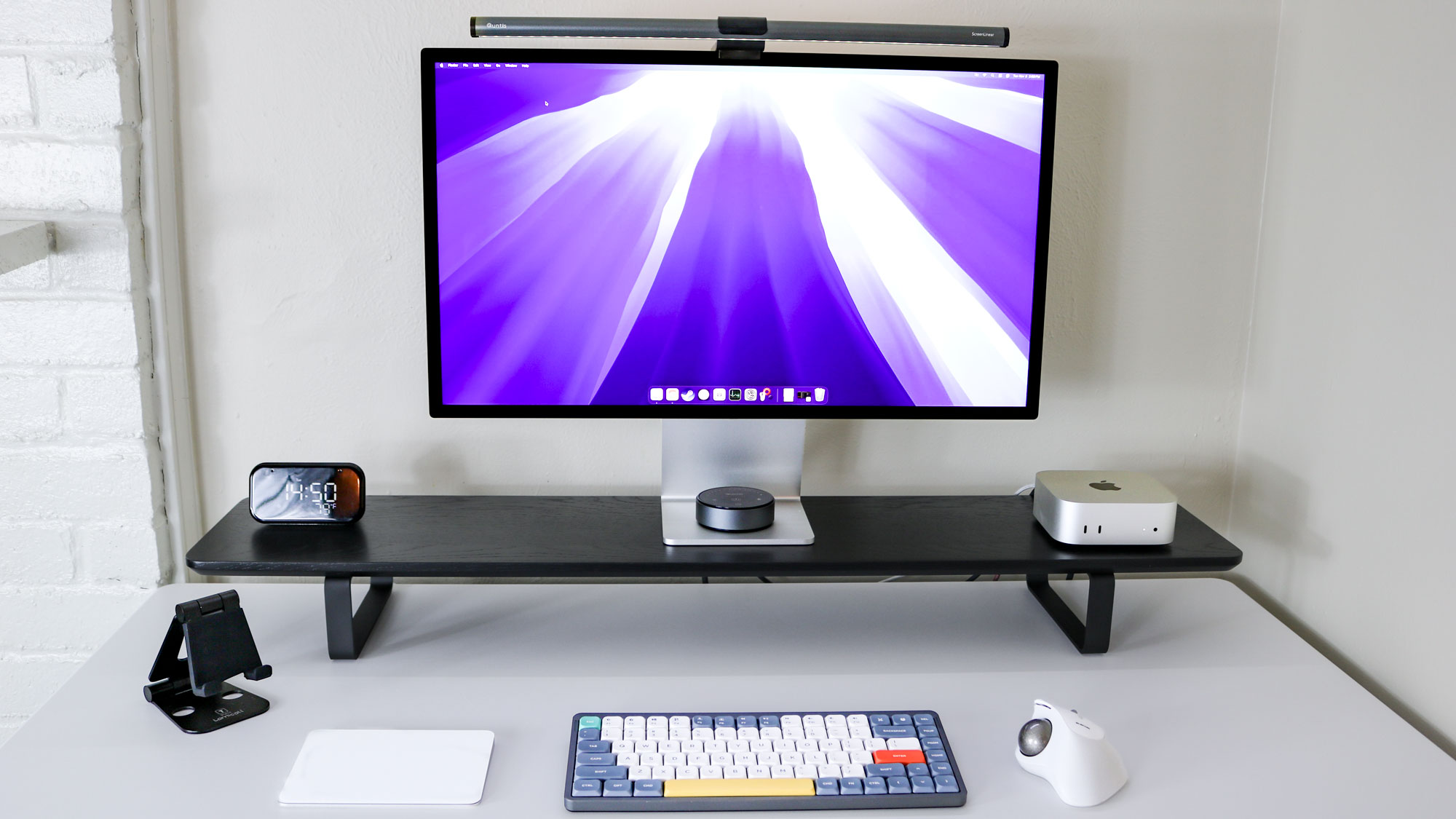 A desk setup built around the Mac mini M4 with a Studio Display, mechanical keyboard, trackball mouse and other accessories