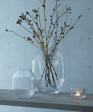 Glass vase, lavender in a vase, flowers in a home, flowers next to a candle