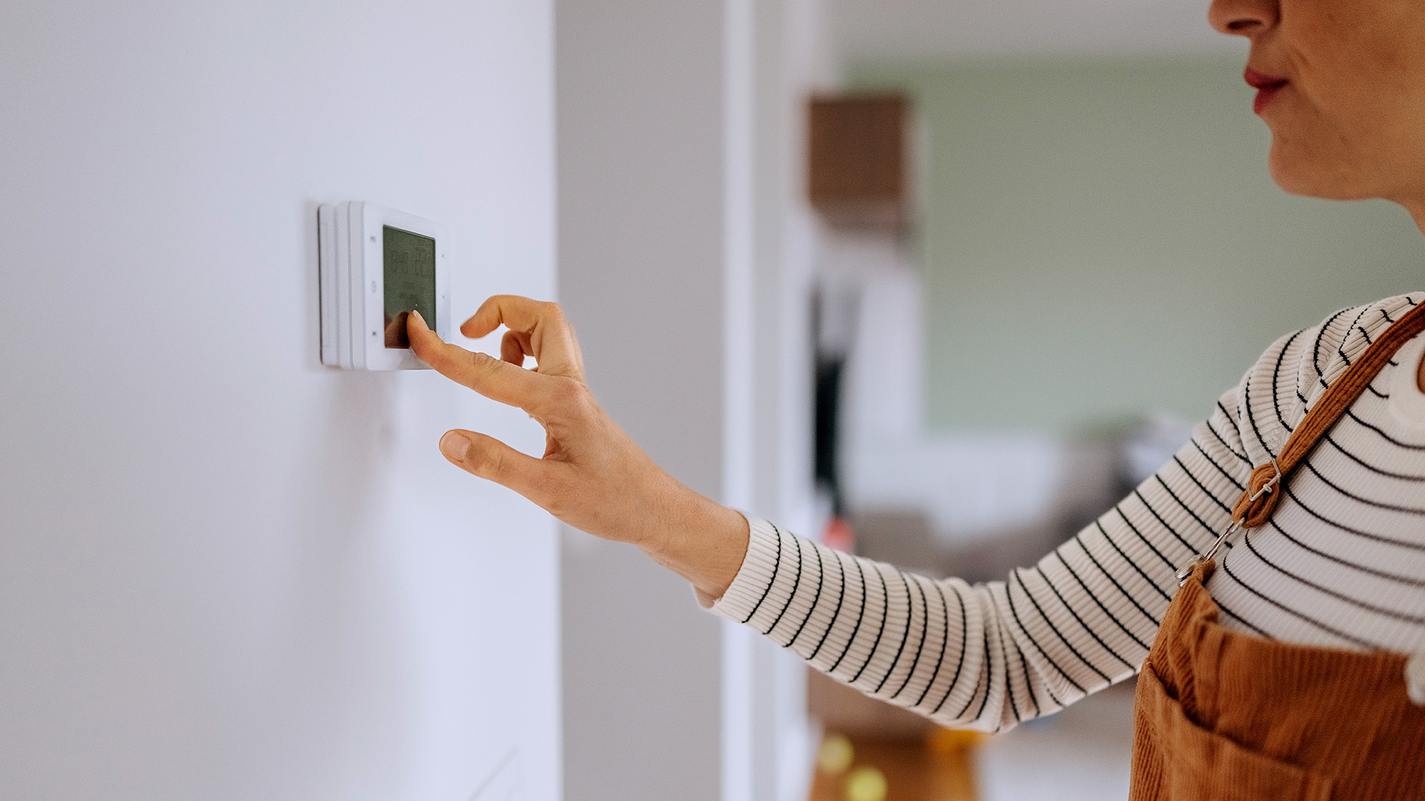Woman setting thermostat