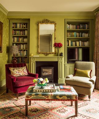 living room with green painted shelves in alcoves and armchairs in front