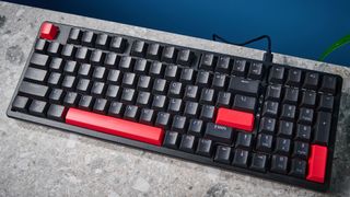 A black Lemokey X5 wired mechanical keyboard with red and black keycaps