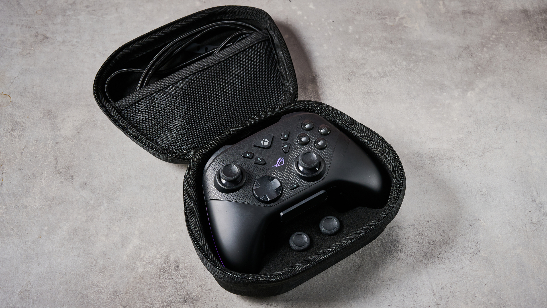 The Asus ROG Raikiri II Xbox Wireless sat in its case, alongside a USB-C cable and spare thumbsticks.