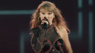 Taylor Swift singing into her snake microphone in the Eras Tour.