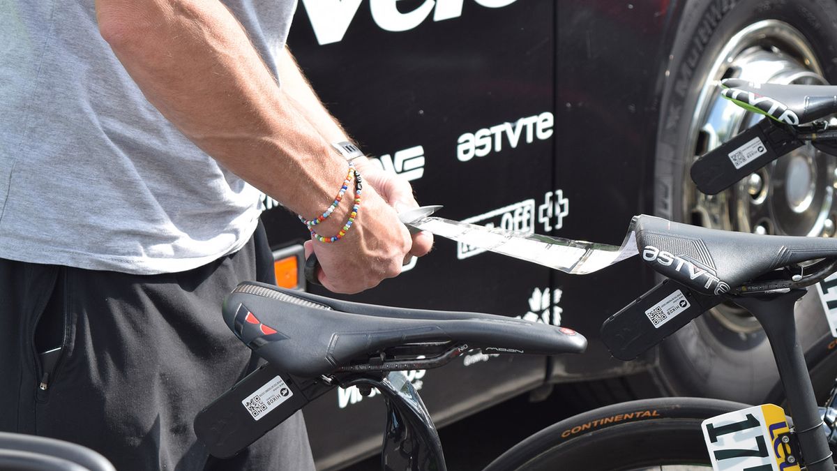 A Dimension Data mechanic cuts pre-prepared course notes ready to be stuck to riders' stems for the stage