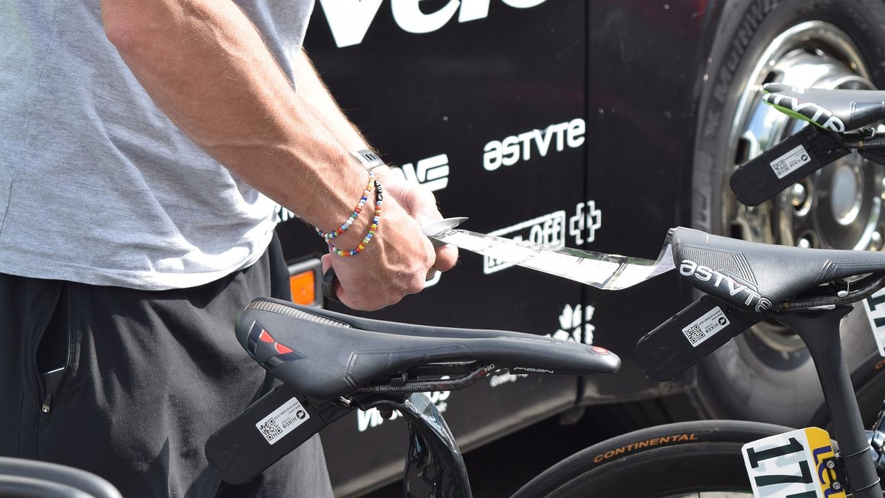 A Dimension Data mechanic cuts pre-prepared course notes ready to be stuck to riders' stems for the stage