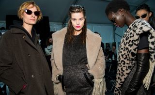 Model wears a black wool coat, another wears a off-white teddy coat, another wears a leopard-print scarf