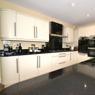 kitchen area with white cabinet and black worktop