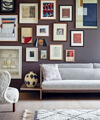 living room with mauve gallery wall and pale grey sofa