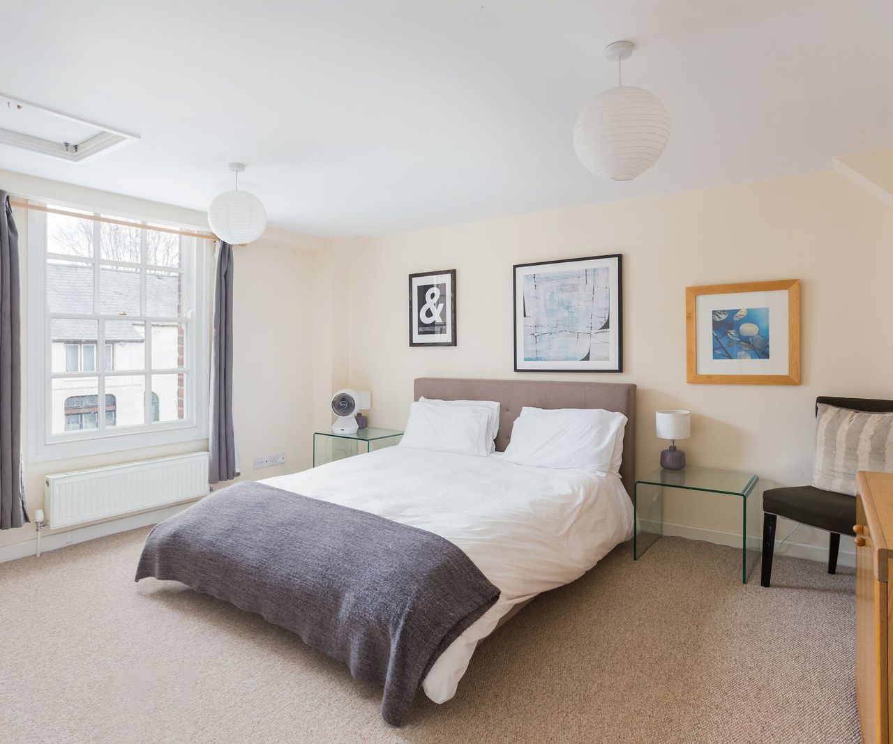 A white bed with paintings on the wall