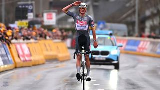 Mathieu van der Poel salutes the crowd while riding his bike to win the E3 Saxo Bank Classic 2025.